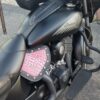 A motorcycle with pink lettering on the seat.
