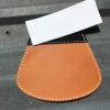 Handmade leather patch with white stitching.