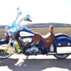 A blue motorcycle with brown leather seat and saddle.