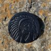 A black coin with an indian head on it