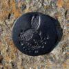A black metal object sitting on top of a rock.
