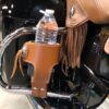 A motorcycle with a brown leather holster holding water.