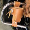 A leather cup holder on the back of a motorcycle.