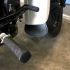 A motorcycle parked in the garage with its pedals on.