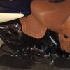 A motorcycle with brown leather seat and tassels.
