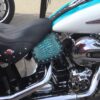 A motorcycle with blue leather seat and matching seat cover.