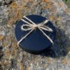 A black box with a bow on top of the rock.