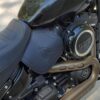 A close up of the seat and engine on a motorcycle.