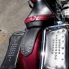 A red motorcycle with black leather and silver studs.