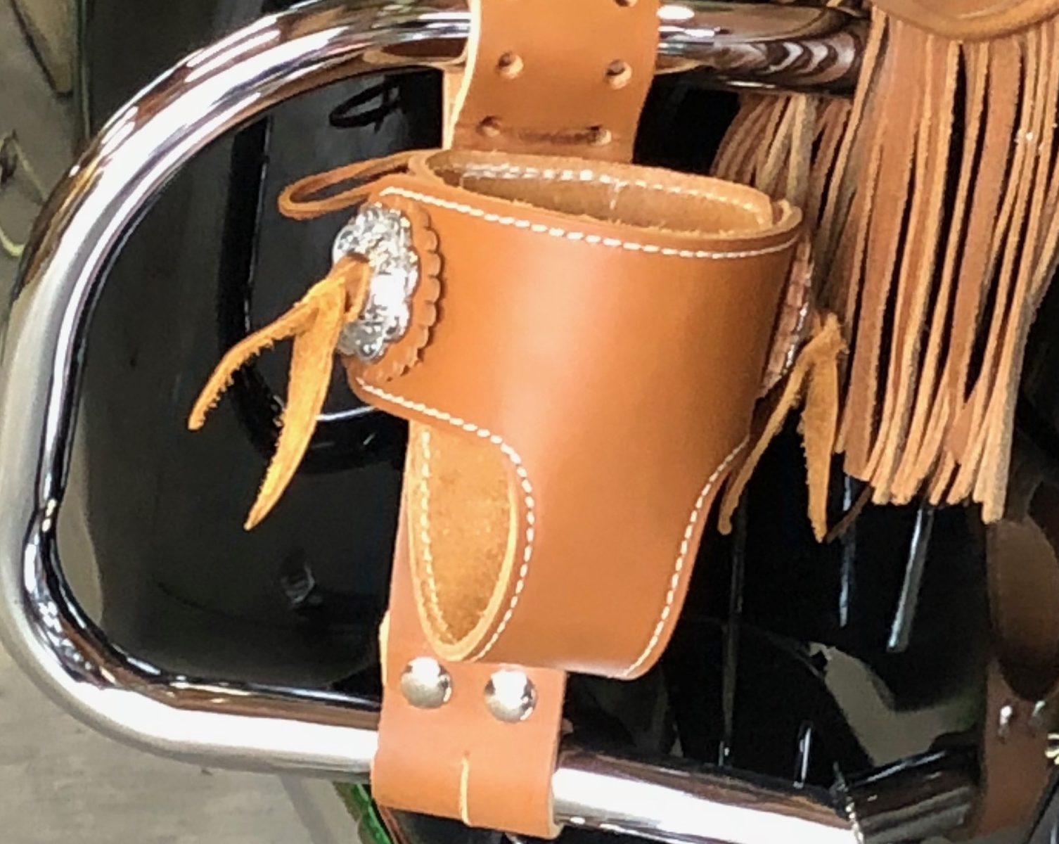 A leather bag hanging on the back of a motorcycle.