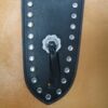 A leather bag with rivets and a metal handle.
