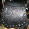 A black leather bag with rivets on it.