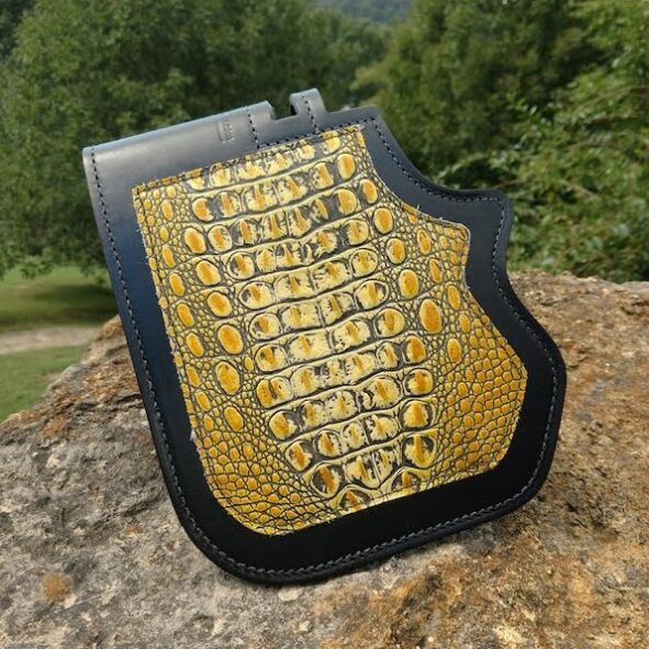 A yellow and black wallet sitting on top of a rock.