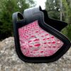 A black and pink purse sitting on top of a rock.