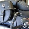A close up of the back of a motorcycle with a leather bag.