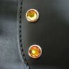 A close up of the buttons on a leather bag.