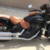 A black and brown motorcycle parked in the driveway.