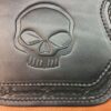 A black leather case with a skull on it.