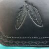 A close up of the leather with two feathers