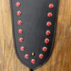 A black leather strap with red rivets on it.