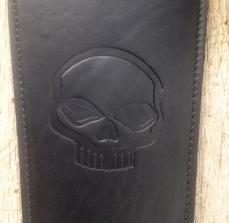 A black leather case with a skull on it.