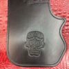 A black leather case with a skull on it.