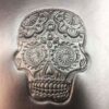 A silver skull with many designs on it.