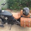 A motorcycle with brown leather bags and helmet on it.