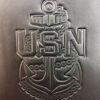 A close up of the u. S. Navy logo on a leather book