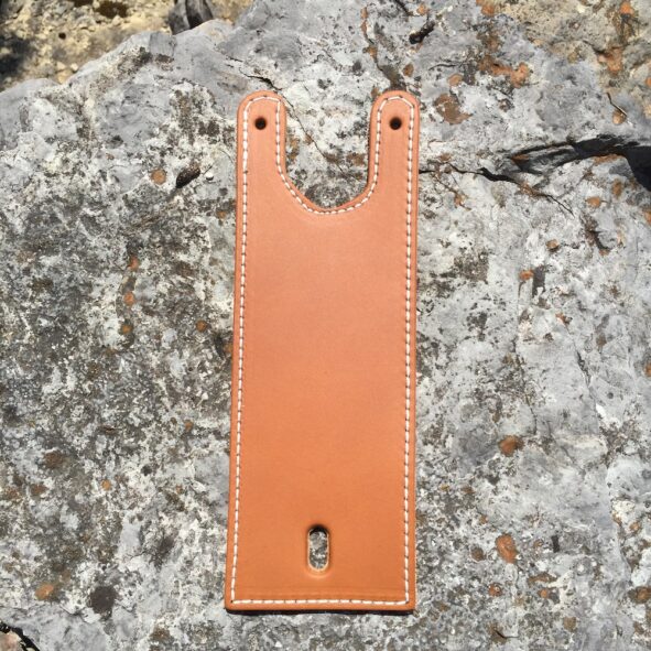 A brown leather wallet hanging on the side of a rock.