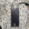 A black leather case is laying on the ground.