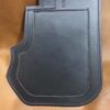 A black leather holster with a pocket on it.