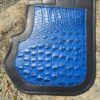 A blue and black car mat on the ground.