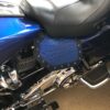 A motorcycle seat with blue leather and black metal.