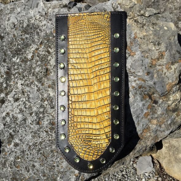 A yellow and black leather wallet on the rocks.