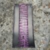 A purple and black wallet sitting on top of a rock.