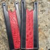 A pair of leather straps with red and black stripes.
