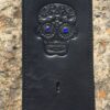 A black leather wallet with a skull on it.