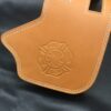 A tan leather case with a fire department logo on it.