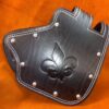 A leather wallet with a fleur de lis design on it.