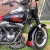 A black and red motorcycle parked in the grass.
