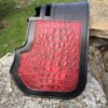A red and black car mat on the ground.