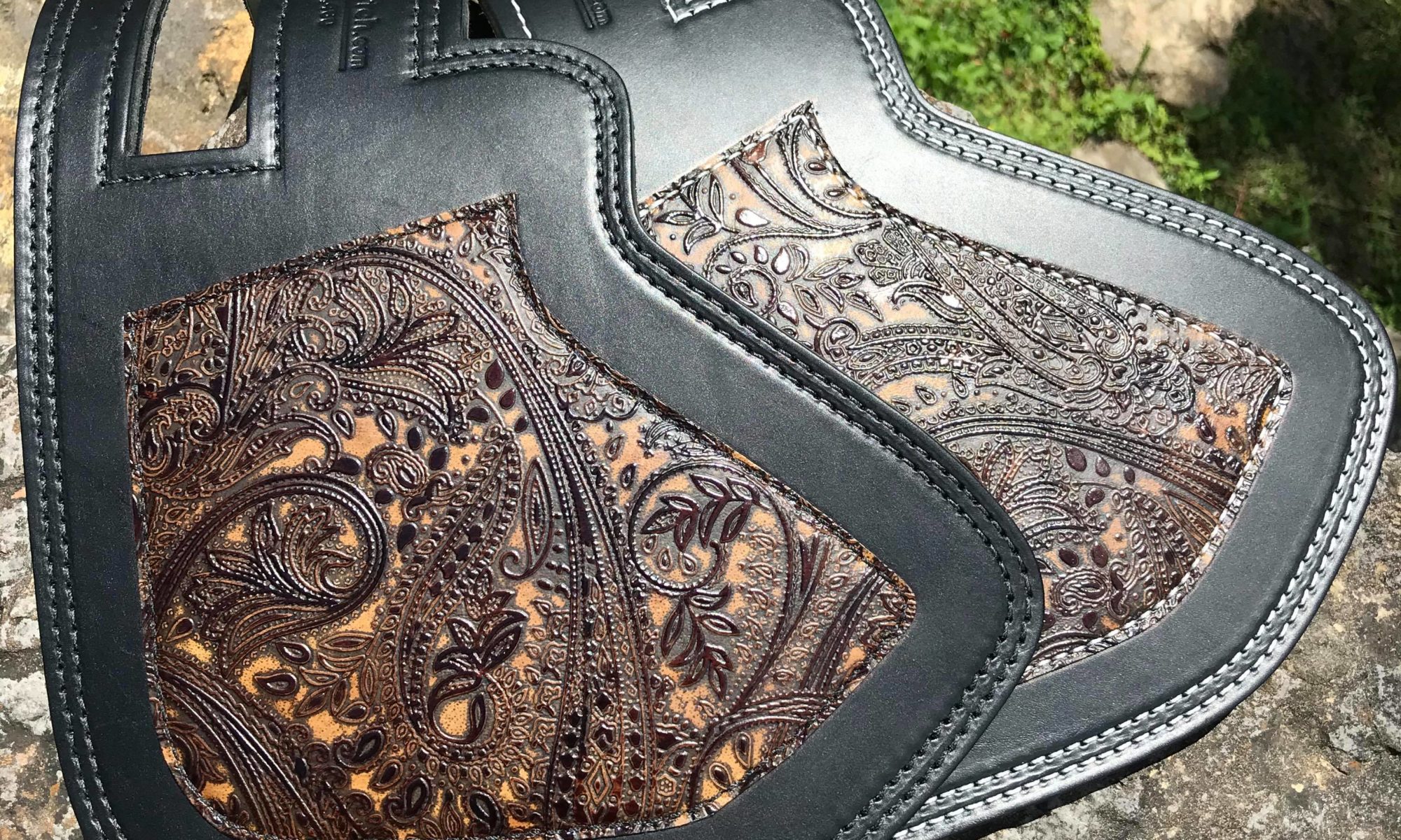 A black leather bag with brown paisley design.