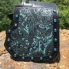 A black and blue purse sitting on top of a rock.
