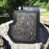 A black and silver wallet sitting on top of a rock.