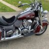 A red and black motorcycle parked on the side of a road.