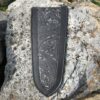 A black leather bookmark on the side of a rock.