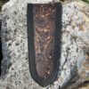 A leather bookmark with an image of a dragon on it.