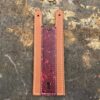A leather bookmark with a red and brown design.