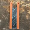 A leather bookmark with a blue and black design.